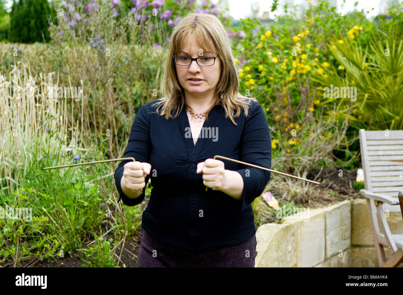 A woman using copper Dowsing rods which are used to find water sources