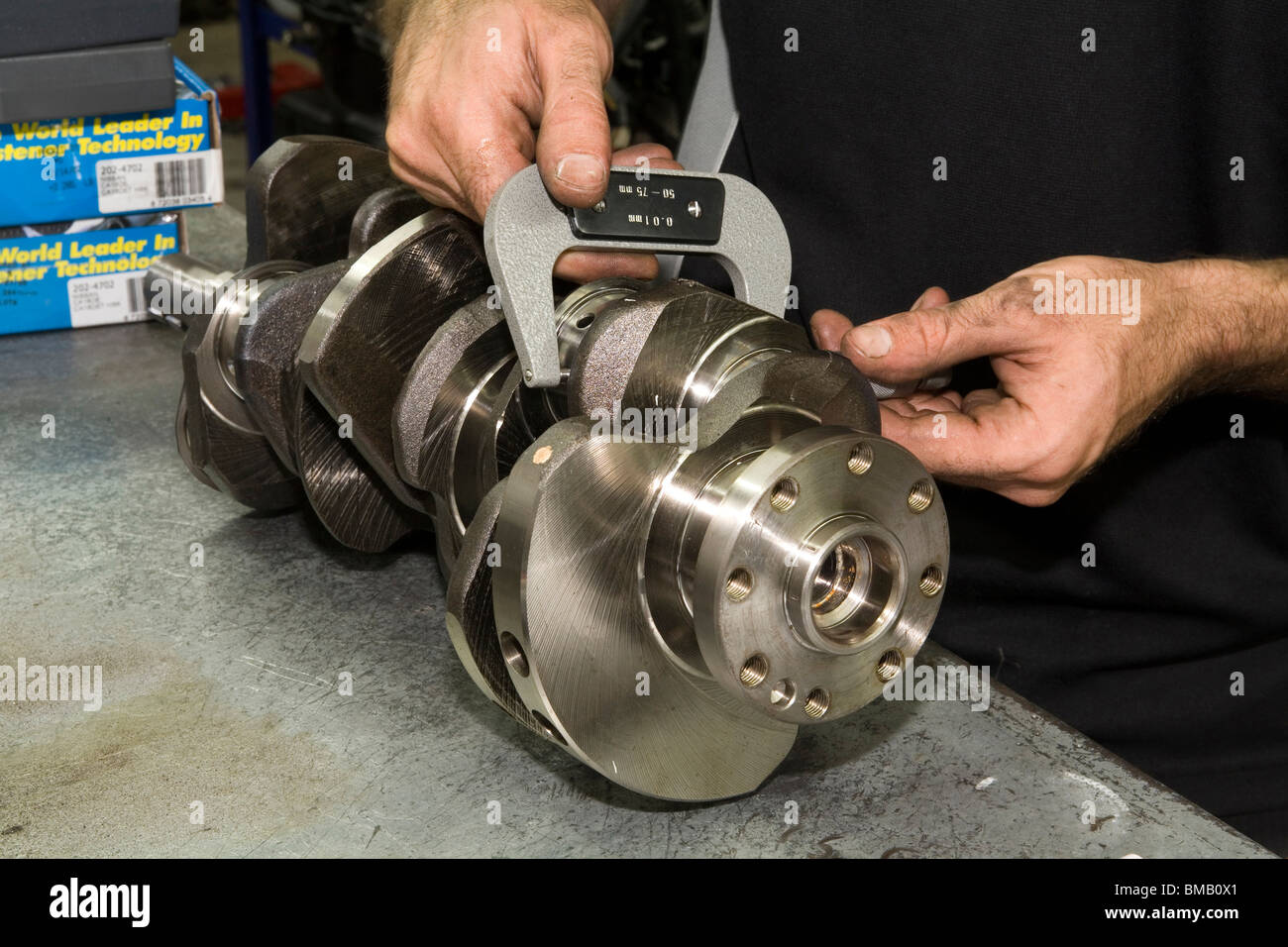 Car engine crankshaft being checked and measured with a micrometer