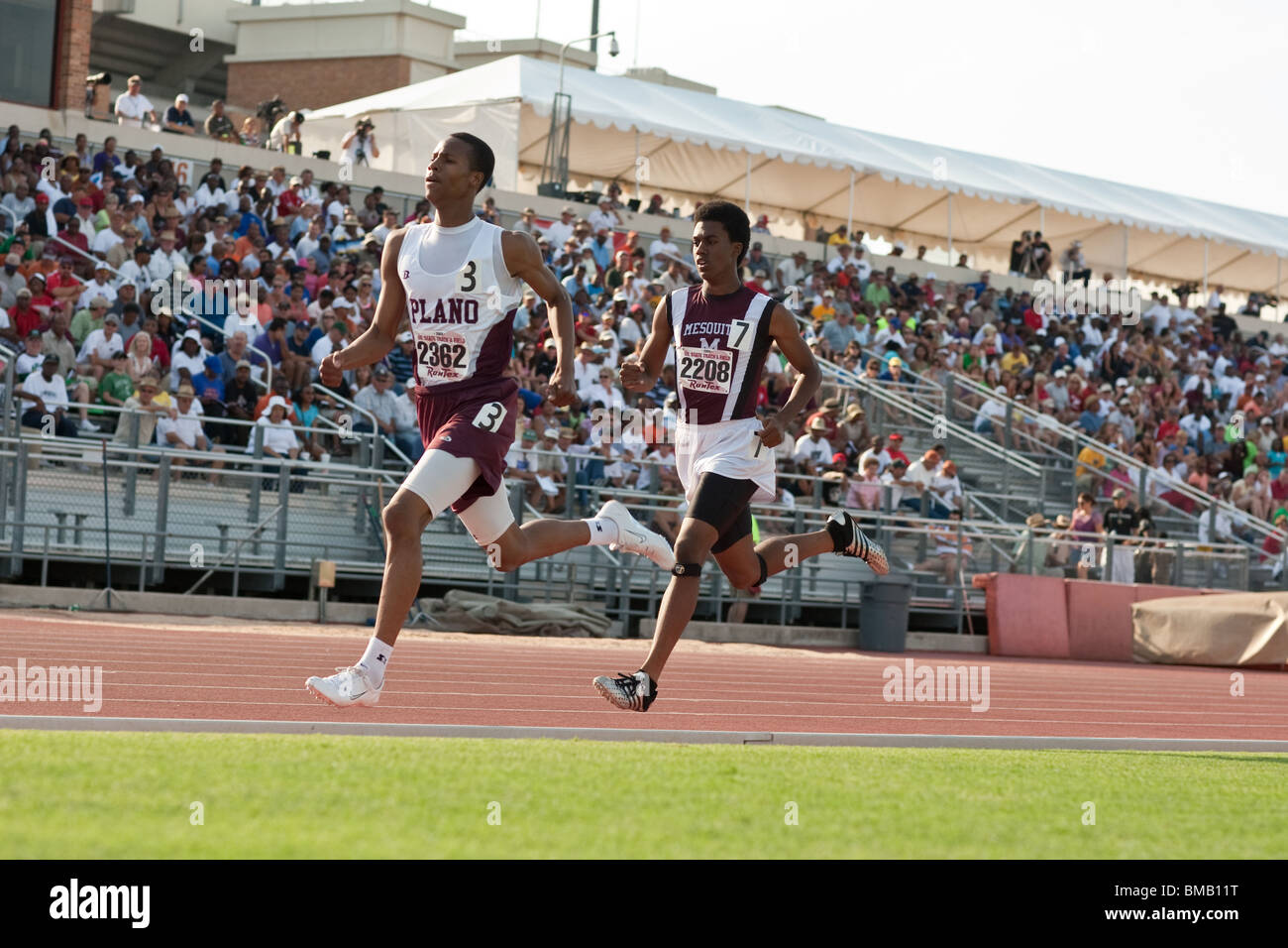 Two high school male runners compete in the Texas state high school track meet in Austin, Texas, USA Stock Photo