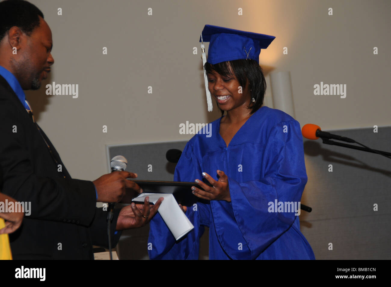 A home schooled high school graduate receives a diploma from her father who combined with her mother taught her for 12 years Stock Photo