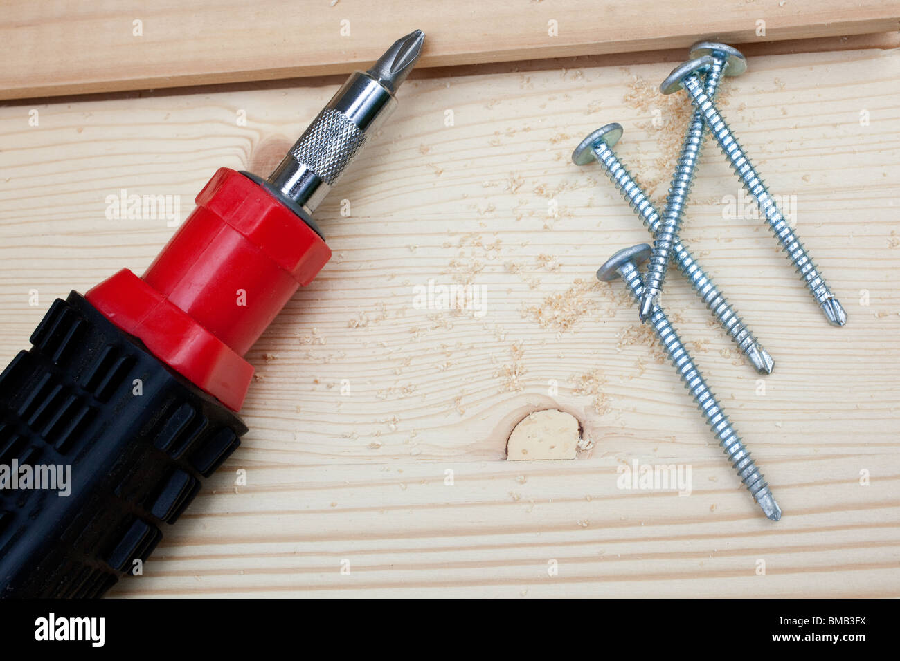 carpentry: screwdriver, four screws and wood planks Stock Photo