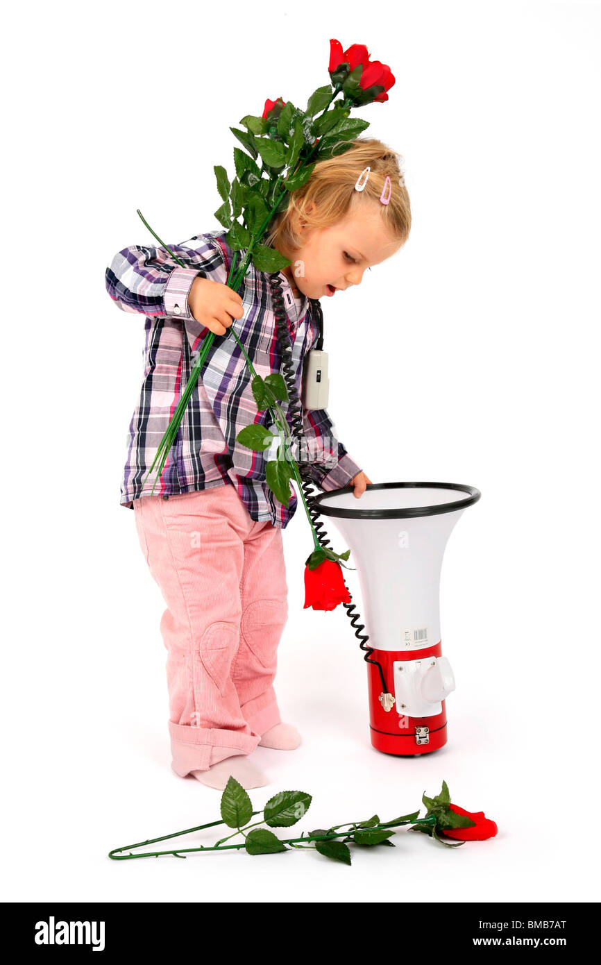 little girl putting red roses into a megaphone Stock Photo