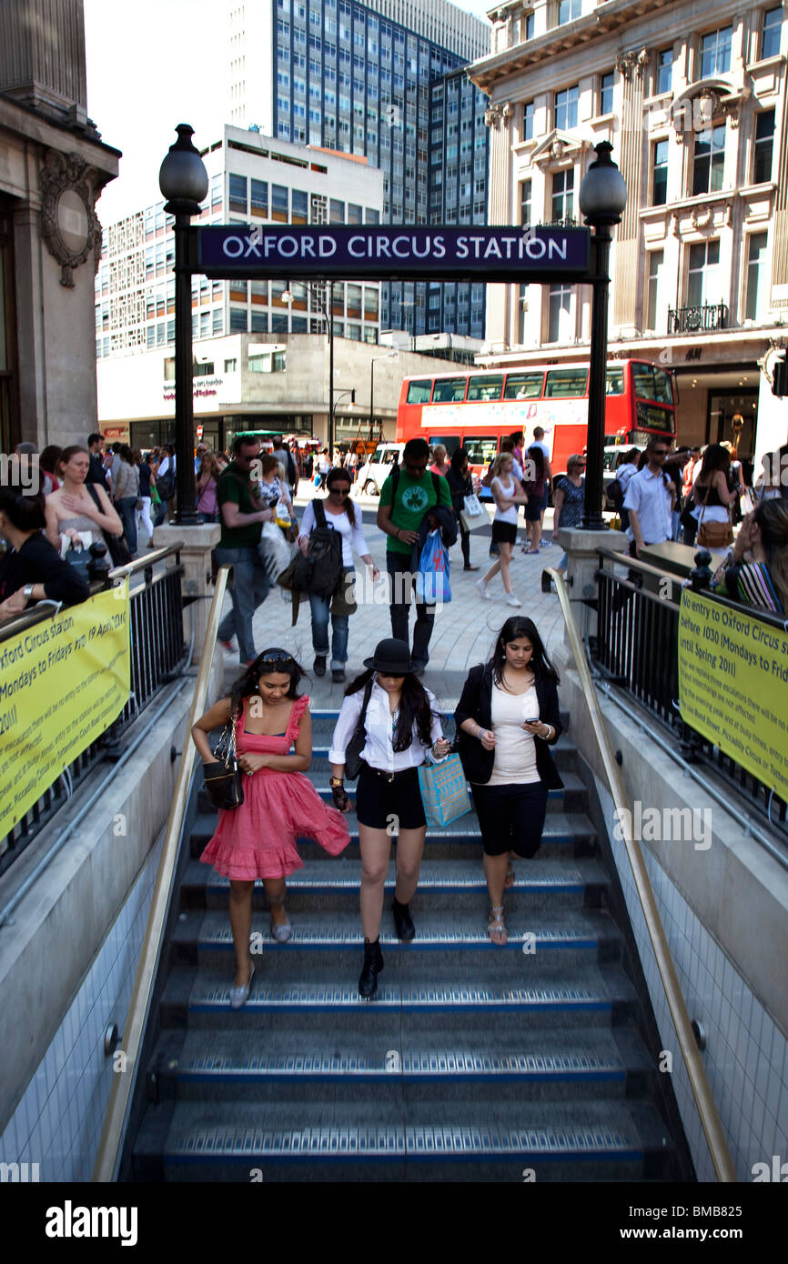 Three Asian girls descending the steps into Oxford Circus underground station. London. Stock Photo