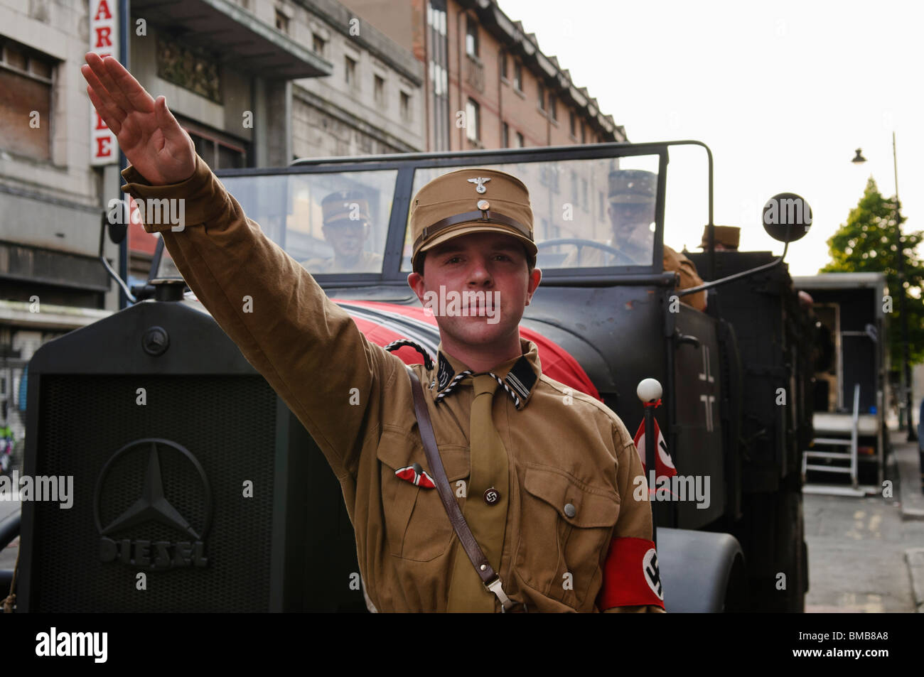Actor dressed in 1930s Nazi soldier uniform performs a 'Hiel Hitler ' salute during filming of a drama set in Berlin. Stock Photo