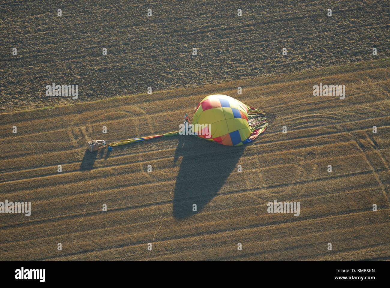 Hot air balloon going flat in wheat field. Meuse, Lorraine region, France Stock Photo