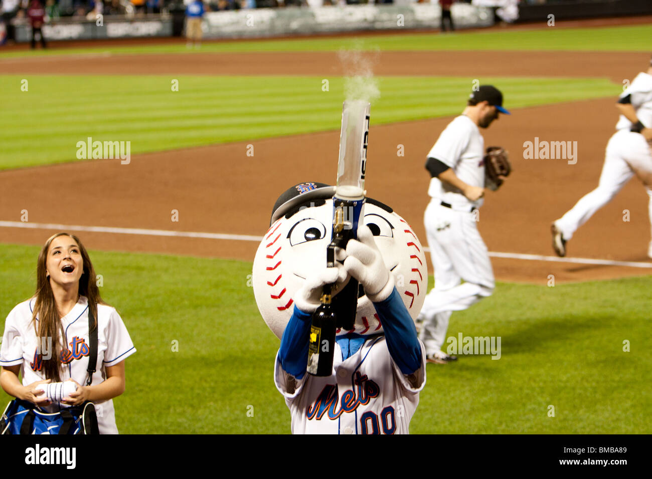 Mascot Mr. Mets at the MLB baseball game shooting a t-shirt gun with smoke at Citi Field Park stadium in New York. Stock Photo