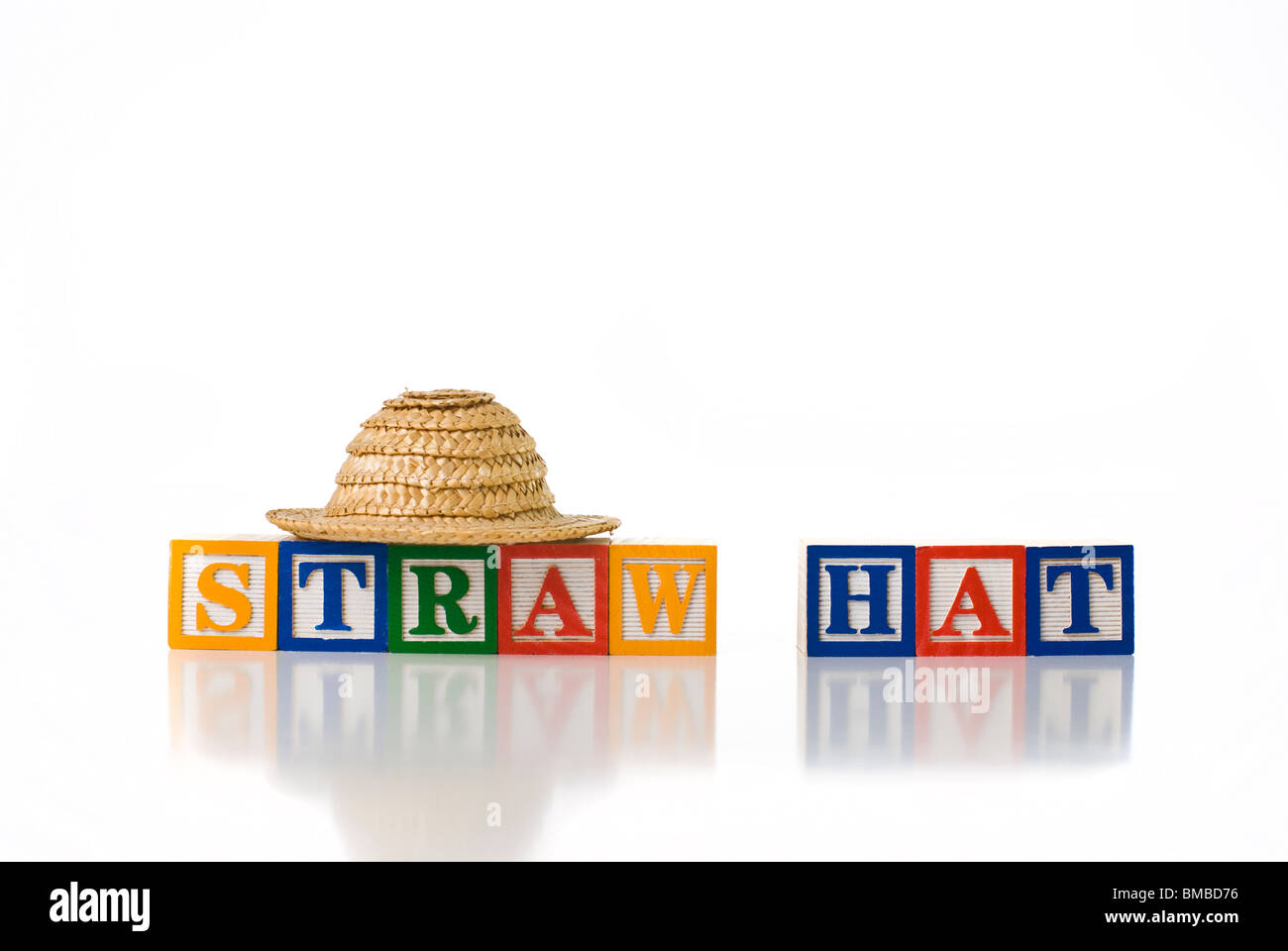 Colorful children's blocks spelling STRAW HAT with a small straw hat