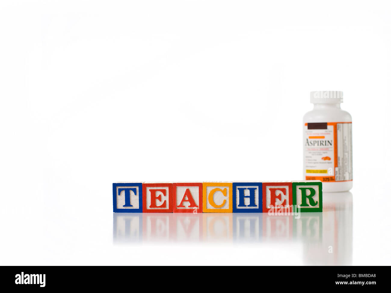 Colorful children's blocks spelling TEACHER with a bottle of aspirin Stock Photo