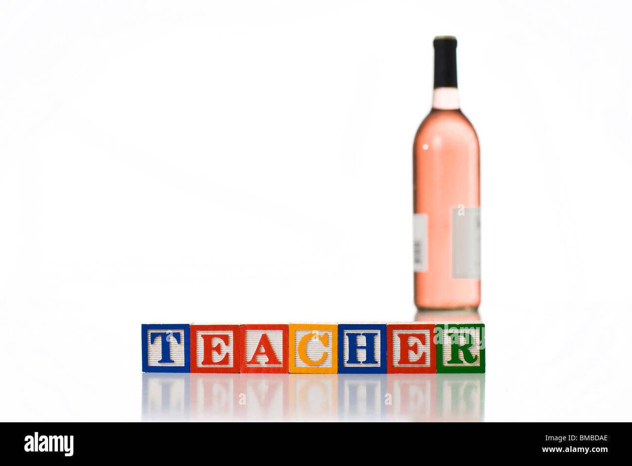 Colorful children's blocks spelling TEACHER with a bottle of wine Stock Photo