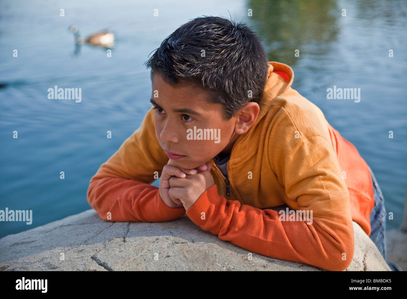 Child praying 10-12 year years old Hispanic American boy outside natural setting contemplating thoughtful dreaming sitting life. MR  © Myrleen Pearson Stock Photo