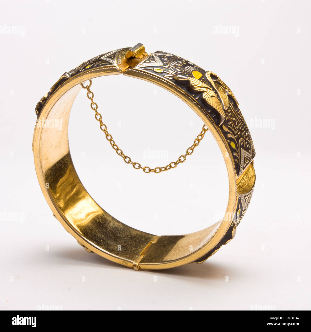 Gold bangle with safety chain isolated against white background Stock