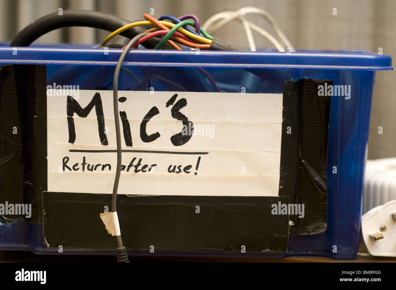 Box full of wires at a recording studio. Box reads ' Mic's return after