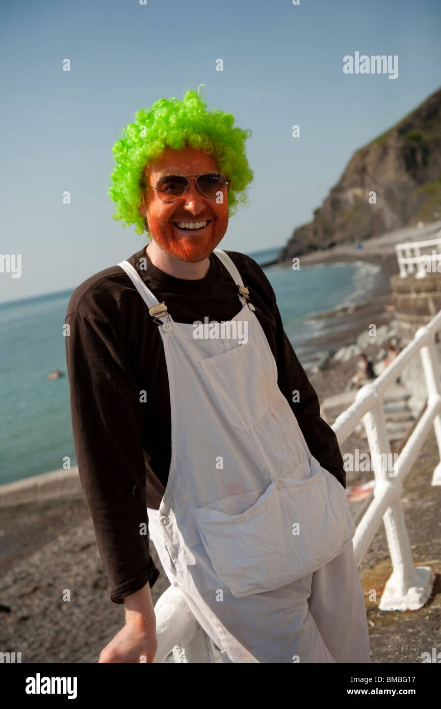 A man wearing a green wig with an orange face on his stag night, Aberystwyth Wales UK Stock Photo