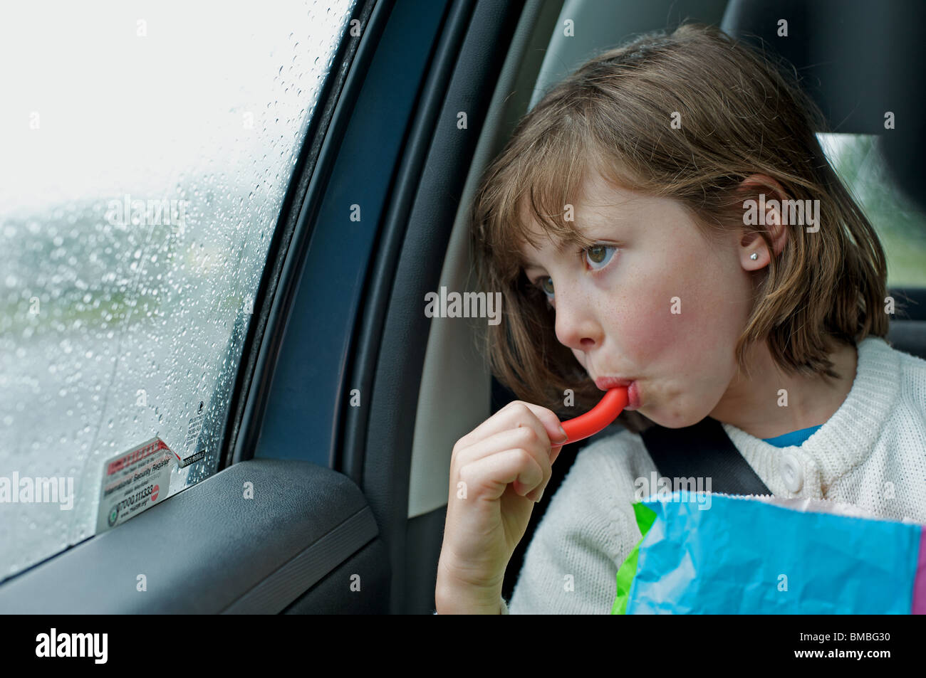 Young girl eating sweets on a long car journey Stock Photo Alamy