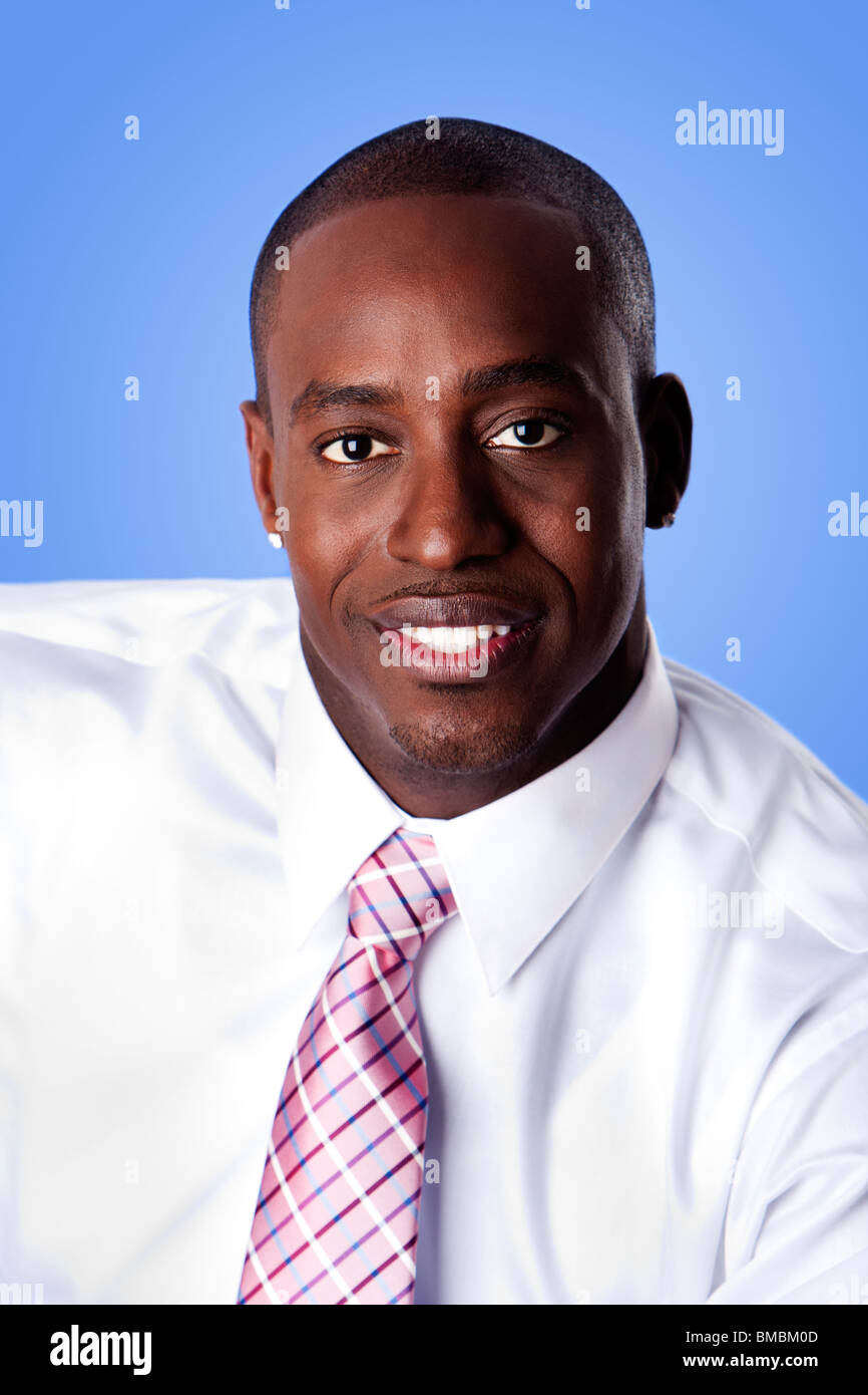 Face of handsome happy African American corporate business man smiling, wearing white shirt and pink with stripes necktie on a b Stock Photo