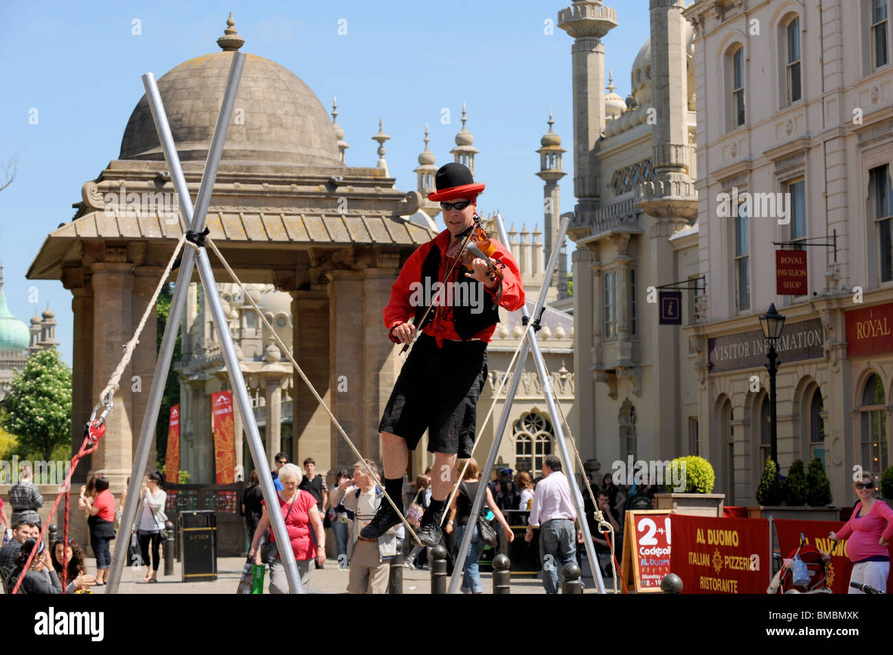 Tight Rope Playing Instruments Busker on a tightrope playing a violin entertains crowds in Brighton ...