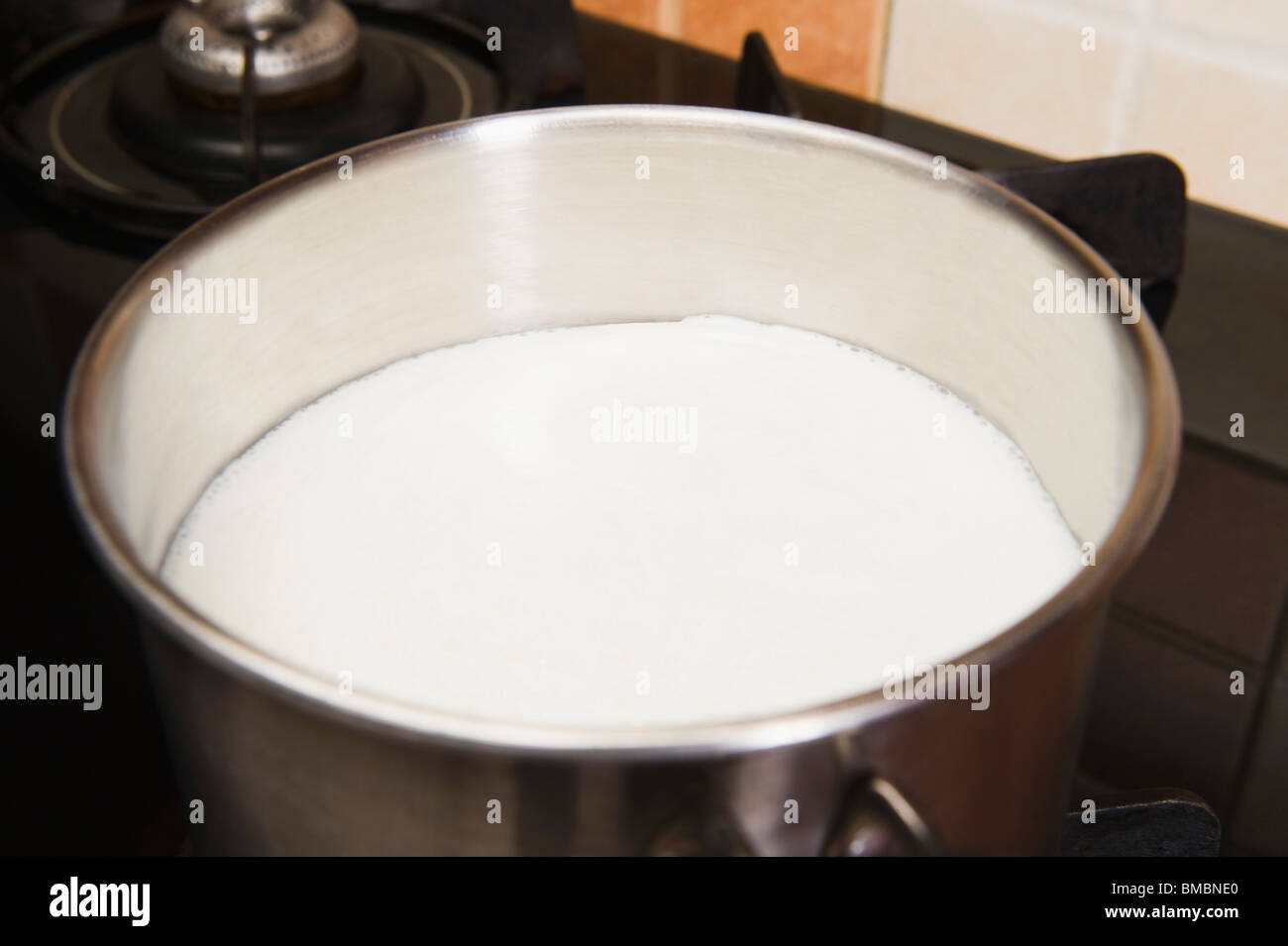 Milk in a saucepan on a gas stove burner Stock Photo Alamy