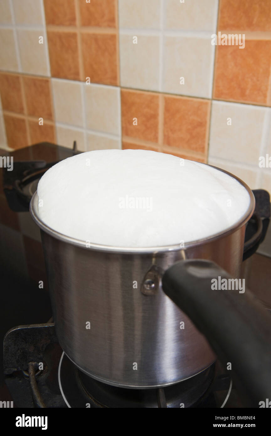 Milk boiling over a pan Stock Photo Alamy