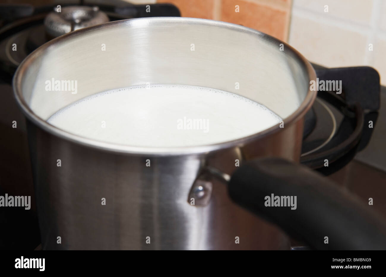 Milk in a saucepan on a gas stove burner Stock Photo - Alamy