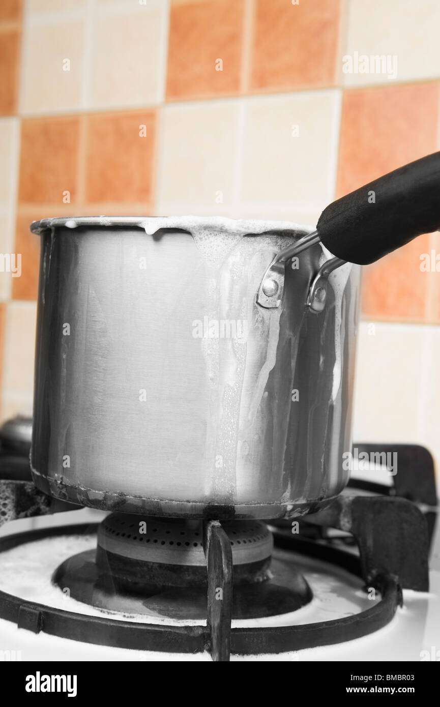 Milk boiling over a pan Stock Photo Alamy