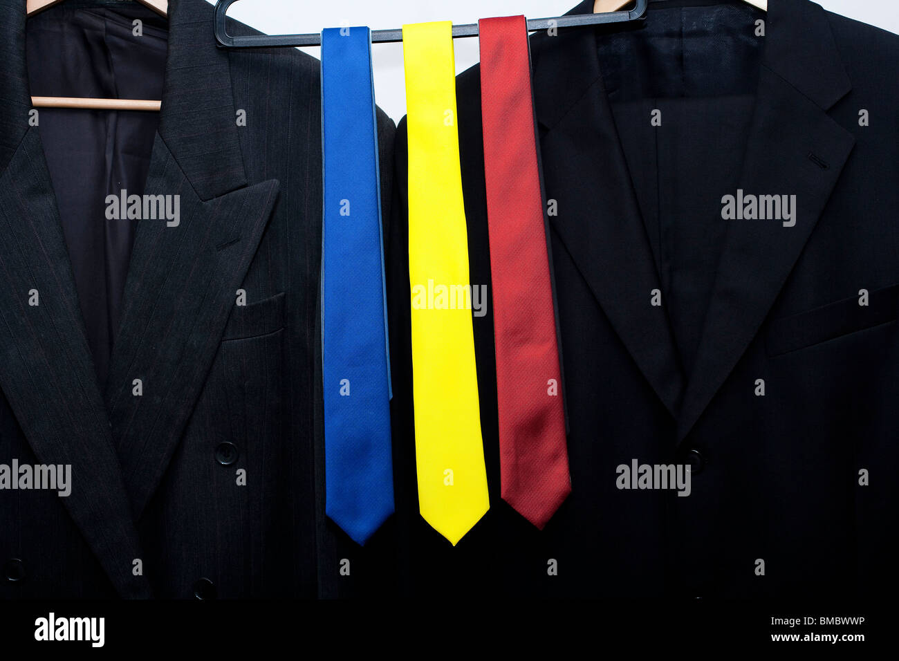 red, blue and yellow ties on a rail in a shop. next suit jackets. metaphor for the UK General Election in 2010 Stock Photo