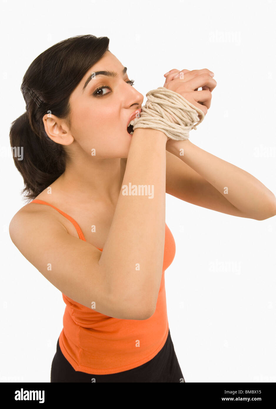 Woman's hands tied with a rope Stock Photo