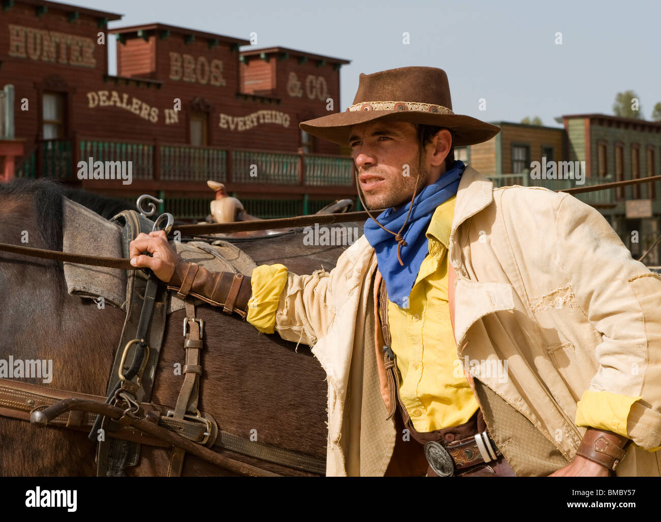 Closeup of a cowboy standing next to his horse in the old west Stock Photo