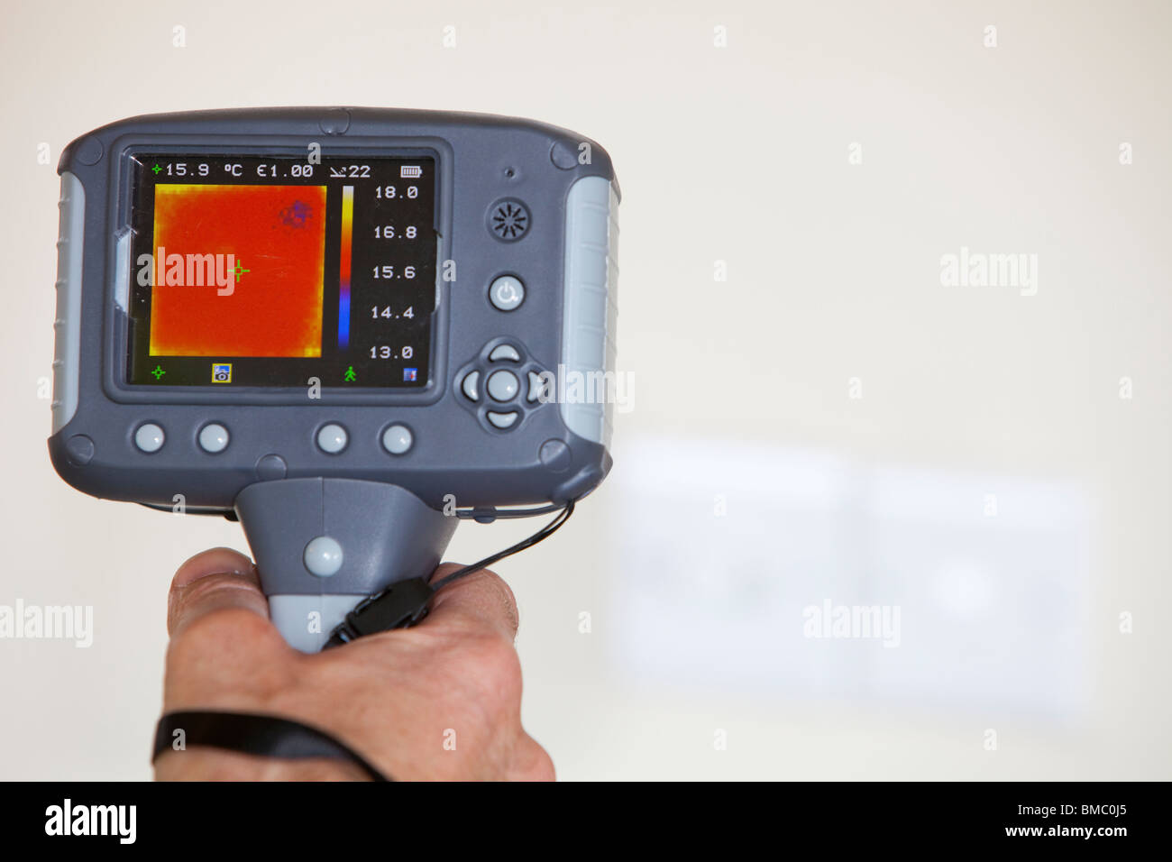 A technician uses a thermal imaging camera to check heat loss around