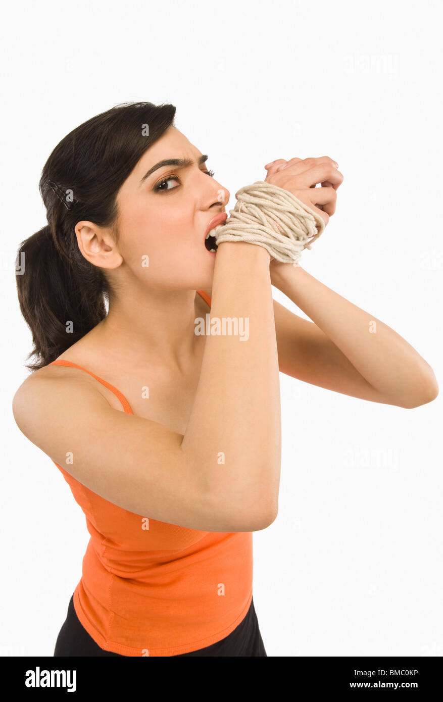 Woman's hands tied with a rope Stock Photo