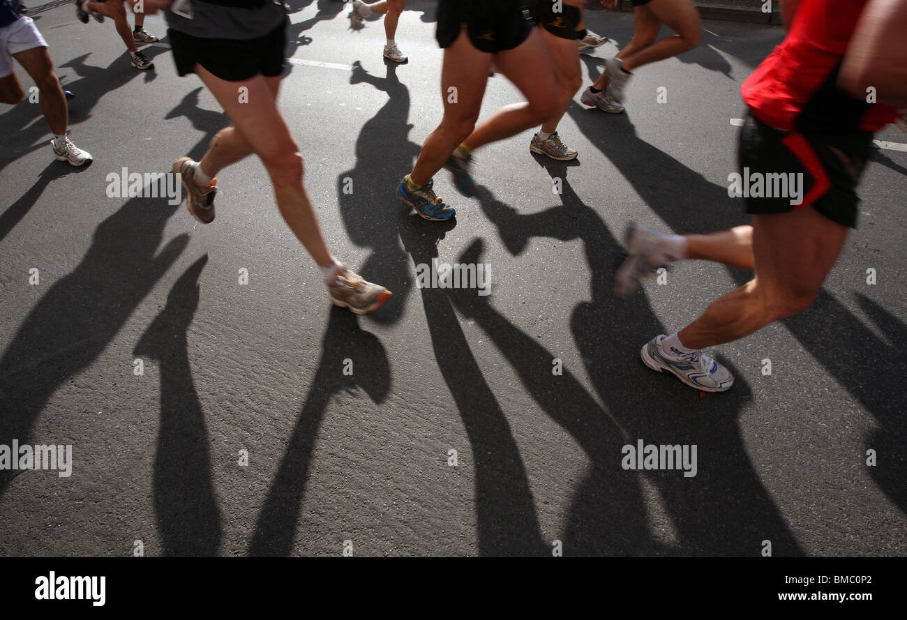 Marathon runners casting shadows on the street, Berlin, Germany Stock
