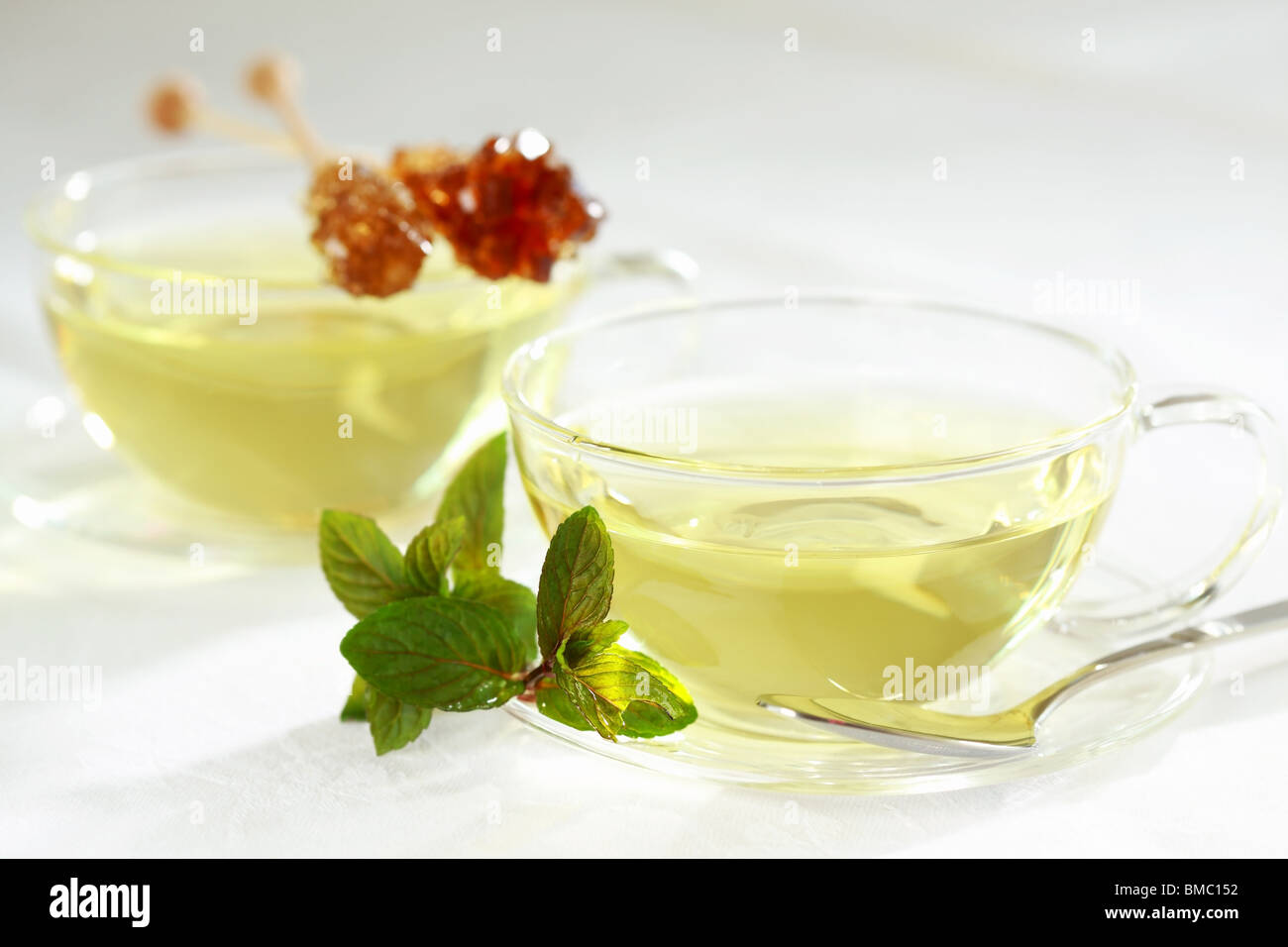 Two cups of green herbal tea with sugar stick Stock Photo