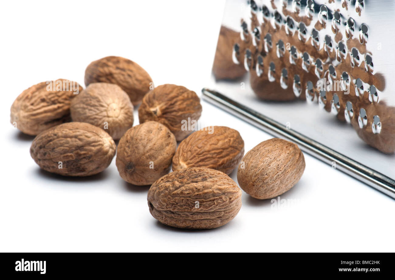 Nutmegs With A Grater On A White Background Stock Photo