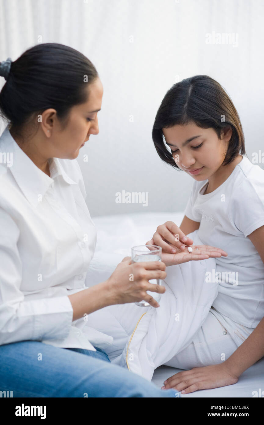 Woman giving medicine to her daughter Stock Photo Alamy