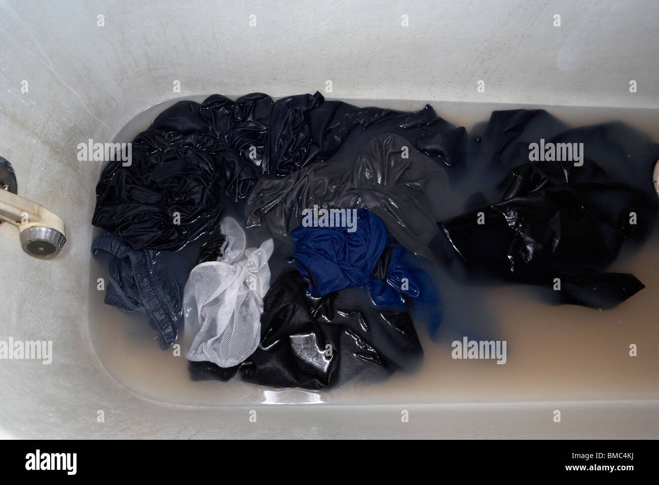 washing dirty clothes in dirty water in a dirty bath property released image Stock Photo
