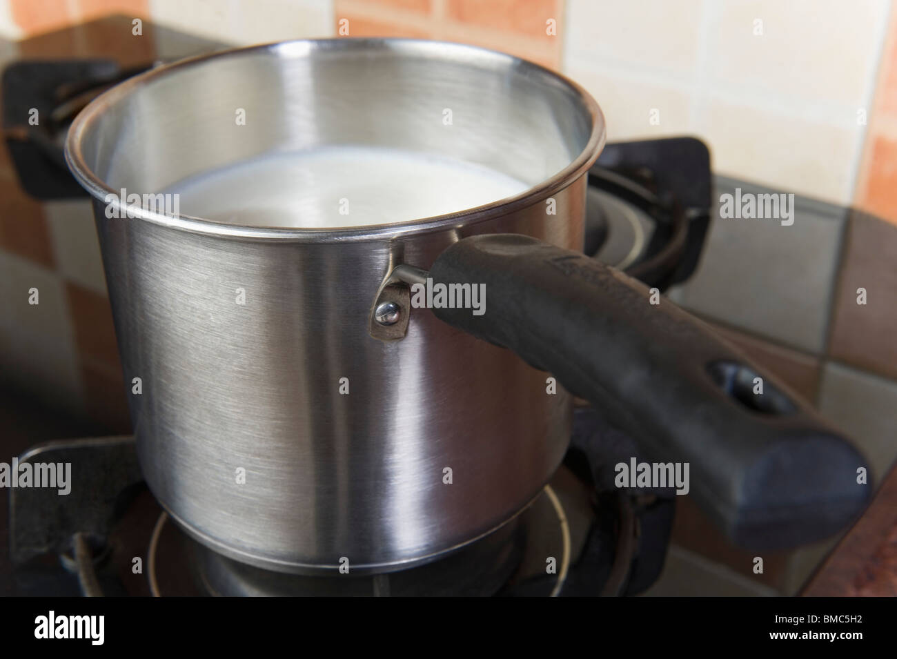 Milk in a saucepan on a gas stove burner Stock Photo Alamy
