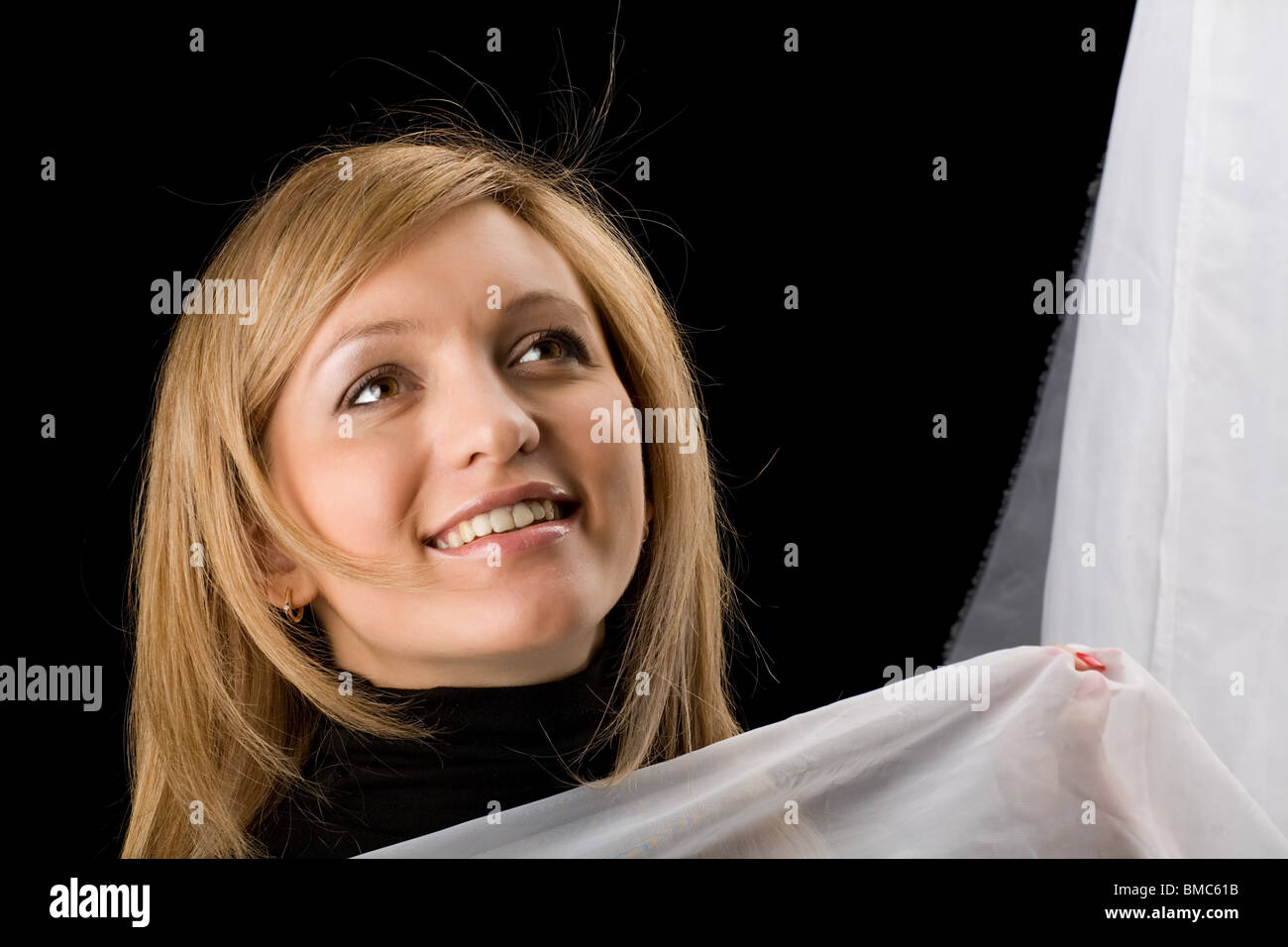 beautiful long-haired girl pensively looks upward, isolated on black background Stock Photo