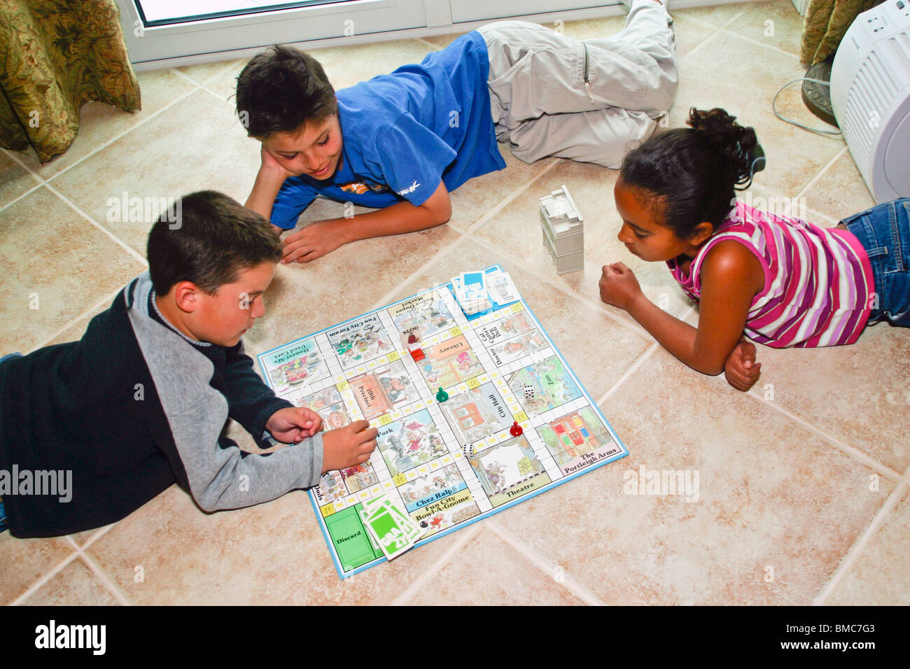 3 ethnic diversity kids boys and girl playing board game indoor  United States  MR ©Myrleen Pearson Stock Photo