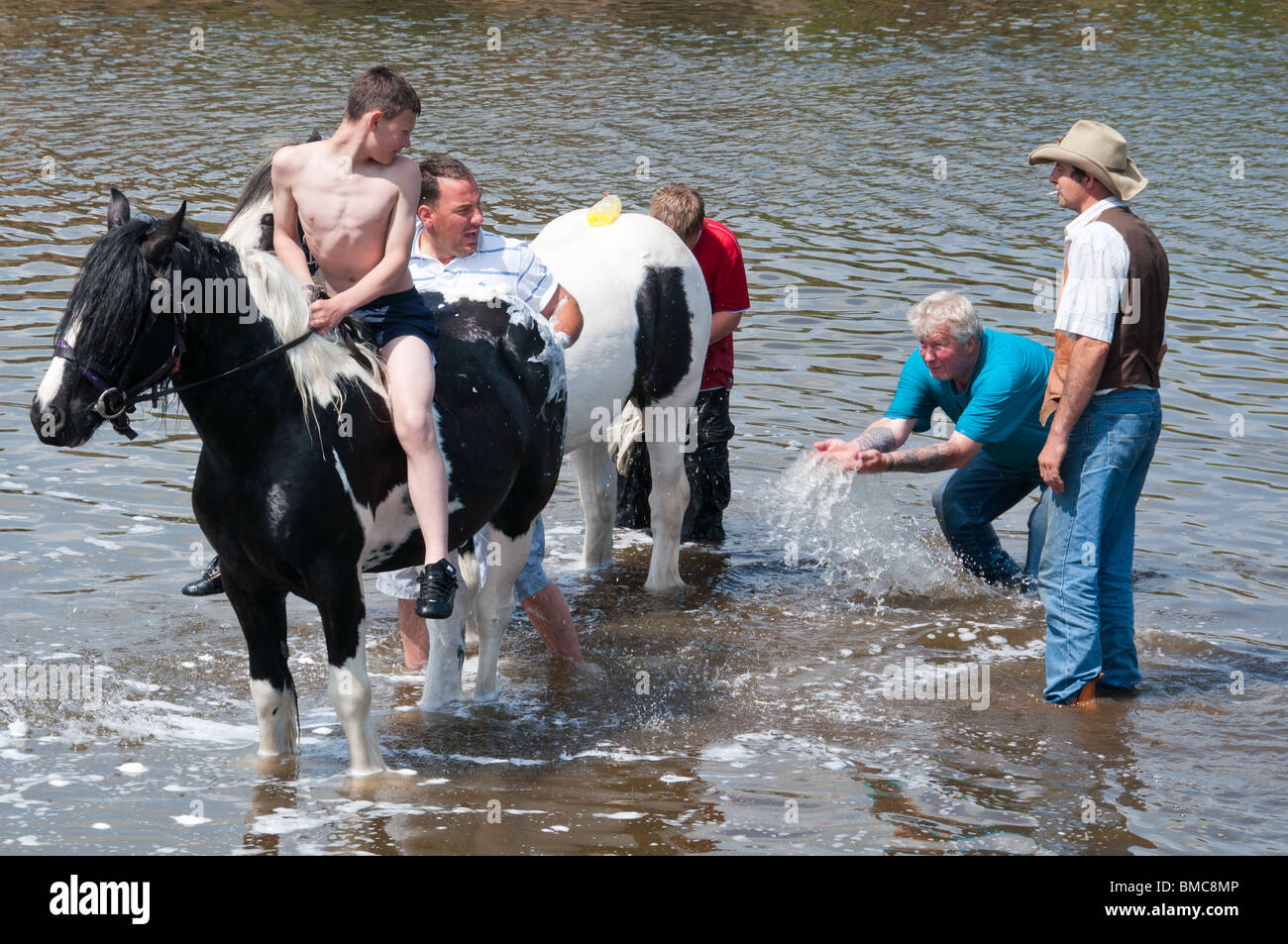 A group of travelers splashing in the river in Middleham, on their way to Appleby Horse Fair Stock Photo