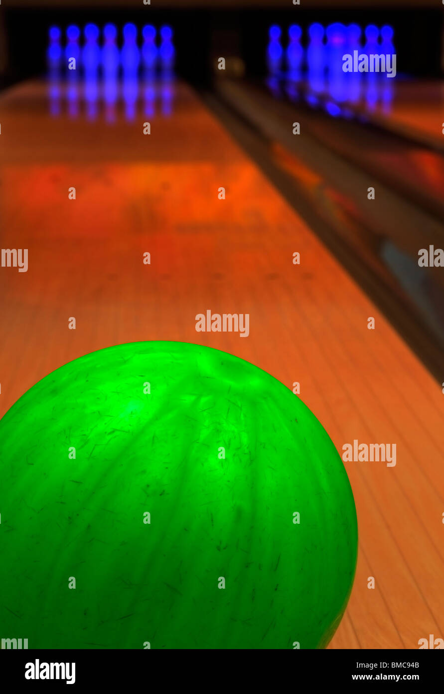 Green bowling ball with pins in background Stock Photo - Alamy