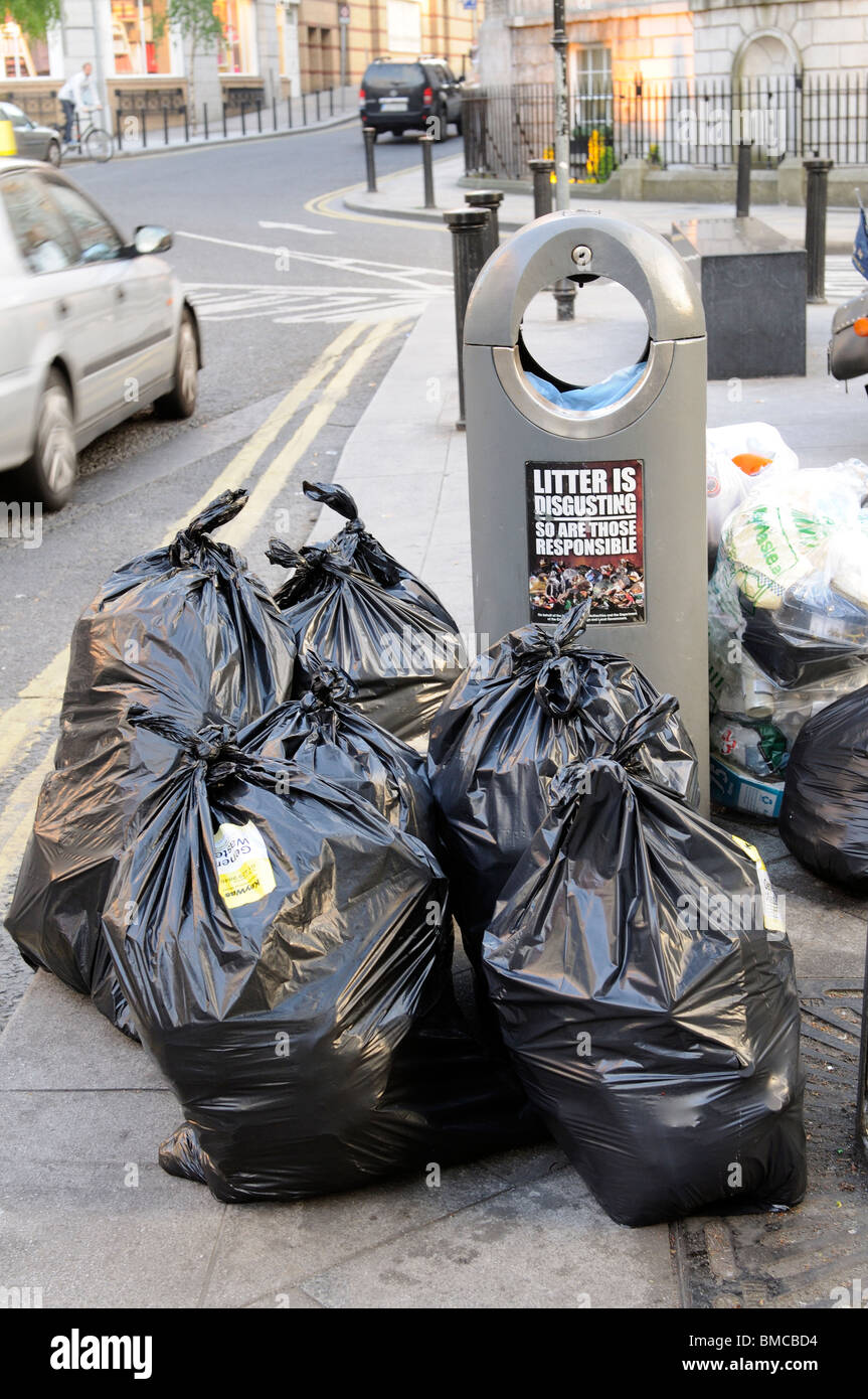 Rubbish bags await collection by Council services on the roadside in a  central Dublin Street Ireland Stock Photo - Alamy