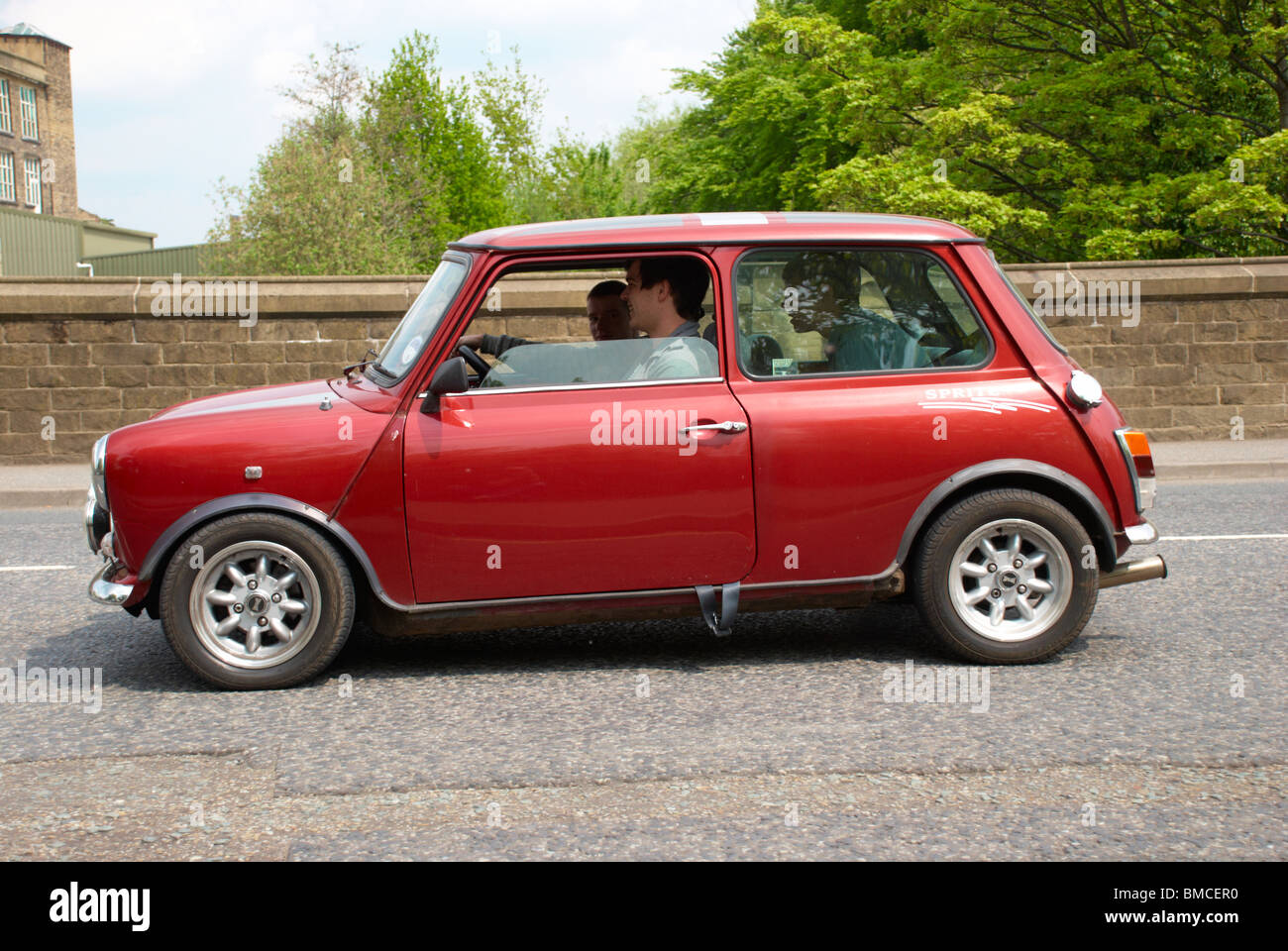 Lads in a red mini (with the seat belt hanging out of the door). Stock Photo