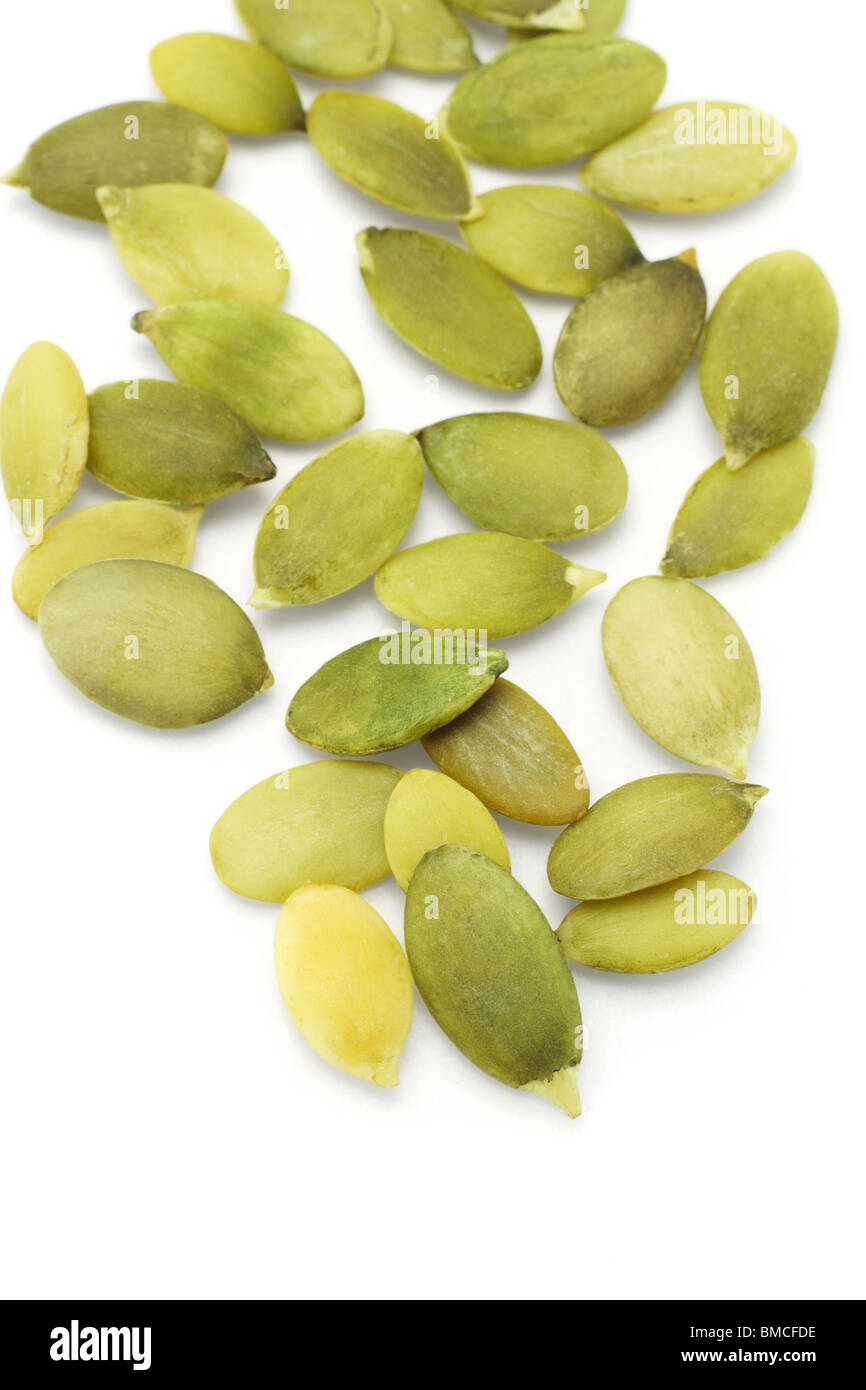 Close up of pumpkin seeds scattered on white background Stock Photo