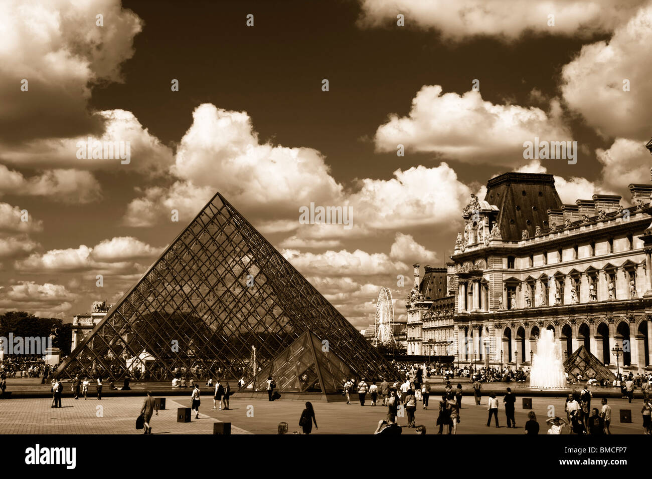 Dramatic Black and white sepia toned Panoramic view of the Glass Pyramid and fountains of the Louvre  museum Paris France Stock Photo