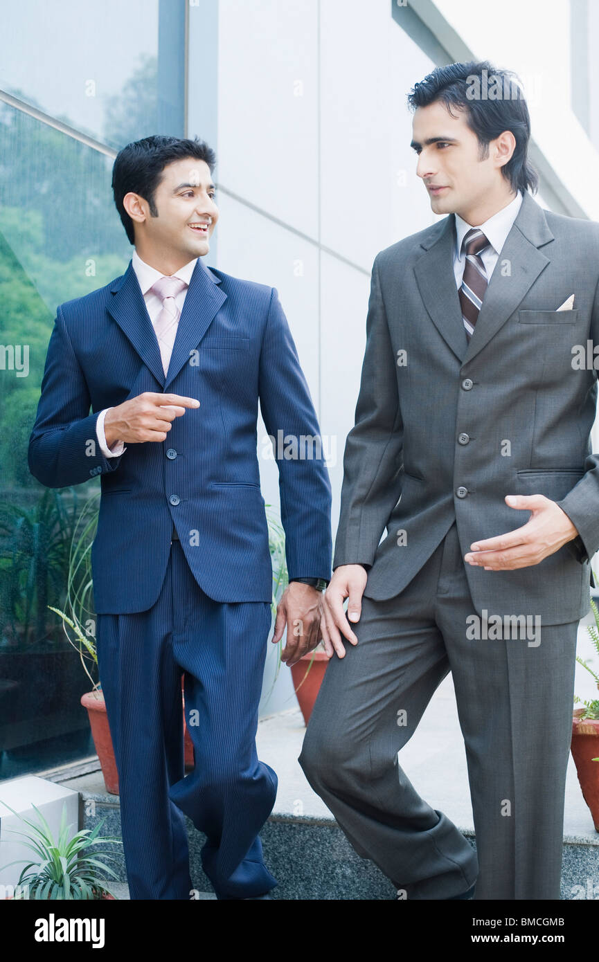 Two businessmen moving down on steps and discussing Stock Photo - Alamy