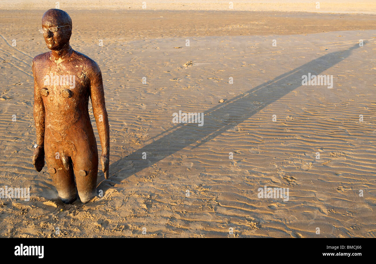 One of the Antony Gormley statues on Crosby beach, Liverpool. The installation is titled ' Another Place. ' Stock Photo