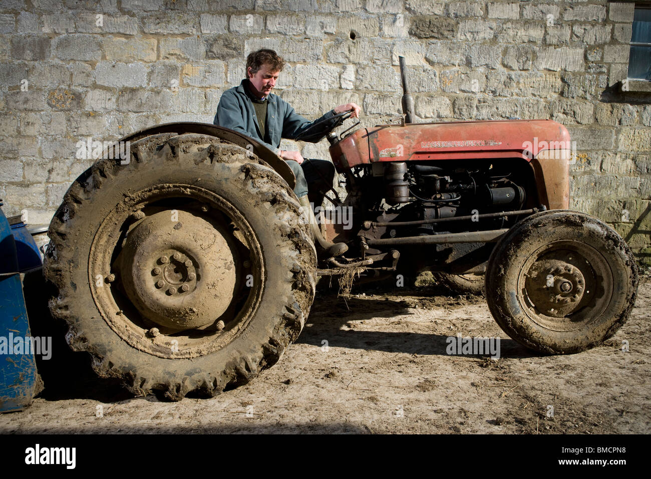 Farmer Jonathan Crump driving his tractor on Standish Park Farm. Oxlynch. Gloucestershire