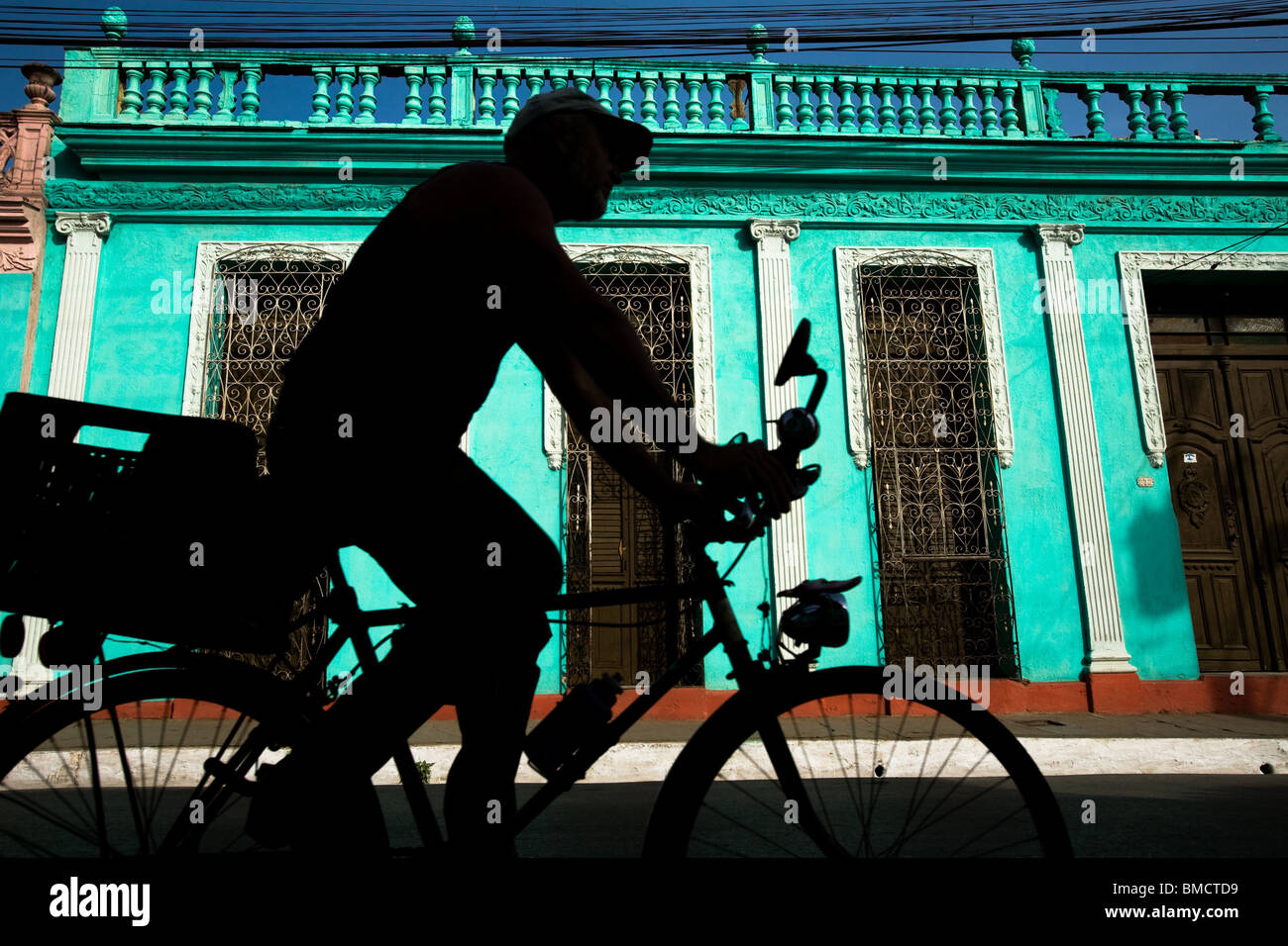 A man rides a bicycle past a colonial building in Trinidad, Cuba on ... - A Man RiDes A Bicycle Past A Colonial BuilDing In TriniDaD Cuba On BMCTD9
