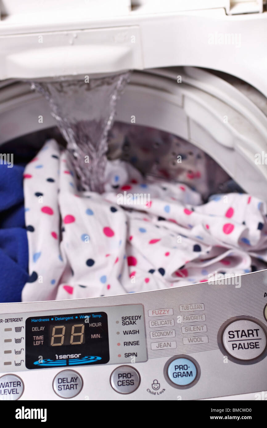 Water running into a loaded toploader washing machine. Foreground focus Stock Photo Alamy