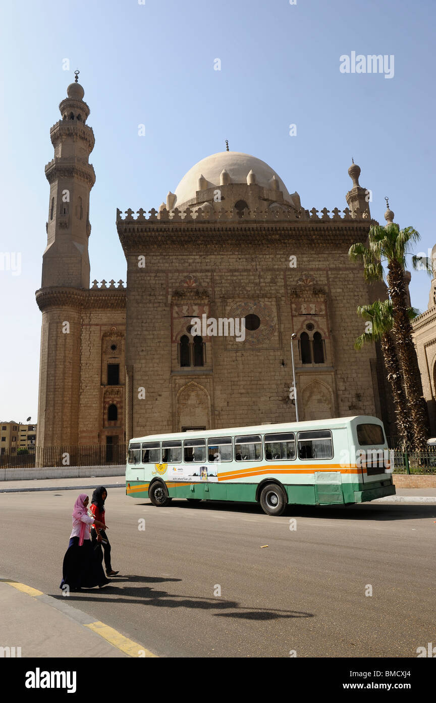 egyptian ladies crossing street , in the background , Sultan Hassan Mosque, Cairo, Egypt Stock Photo