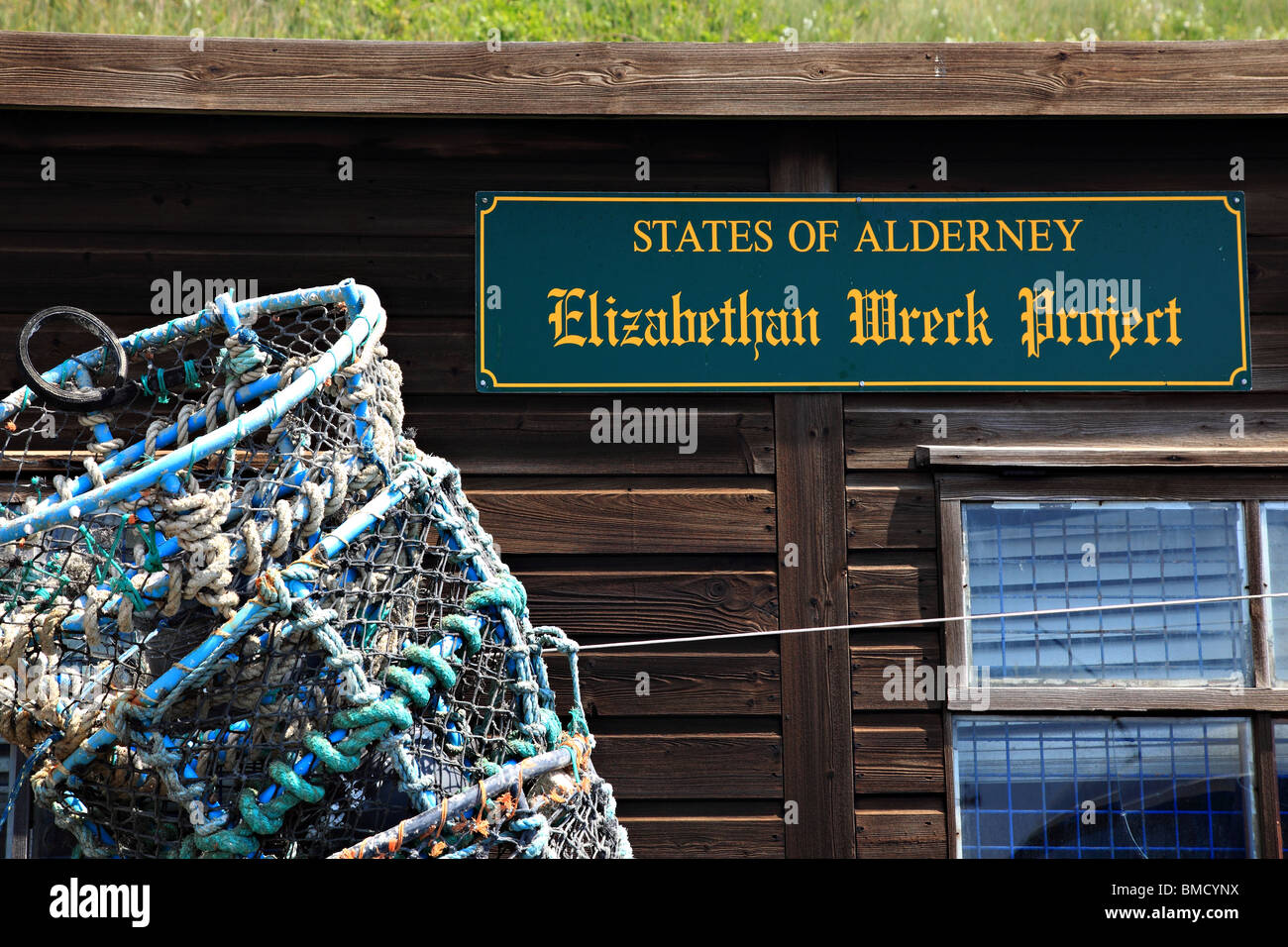 Elizabethan Wreck Project States of Alderney Sign on the hut in the harbour and crab pots, Alderney, Channel Island, UK Stock Photo